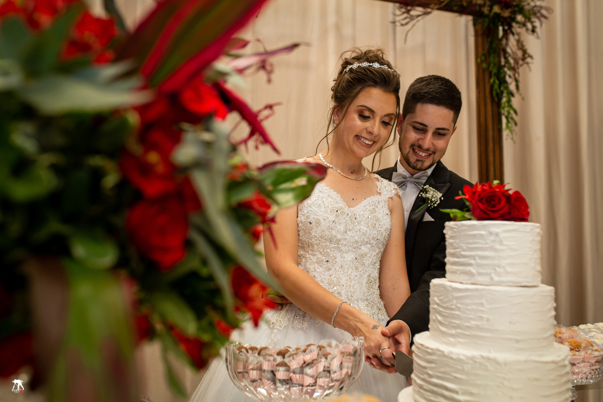 Noivos cortando o bolo no casamento
