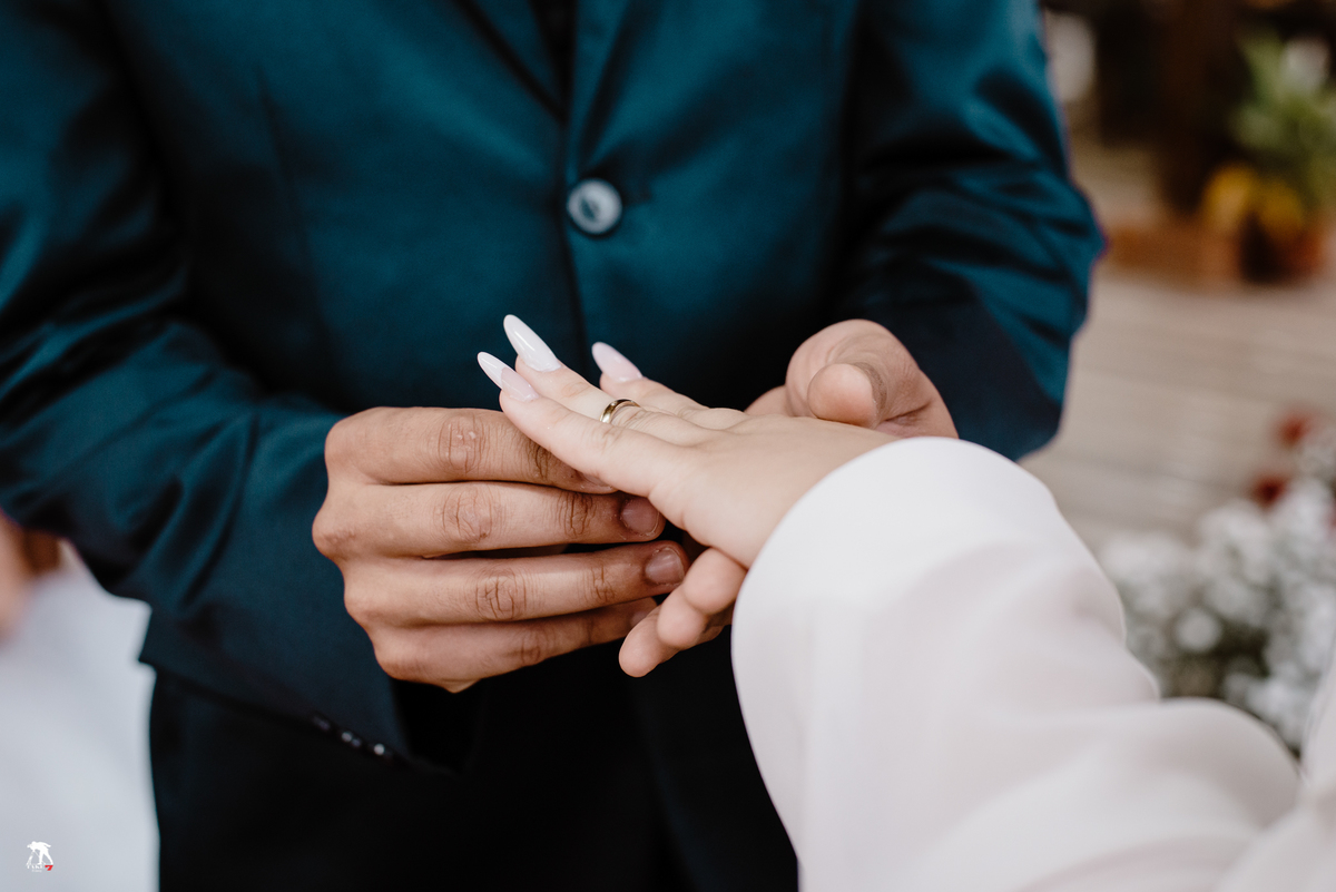 Noivo colocando aliança na noiva 