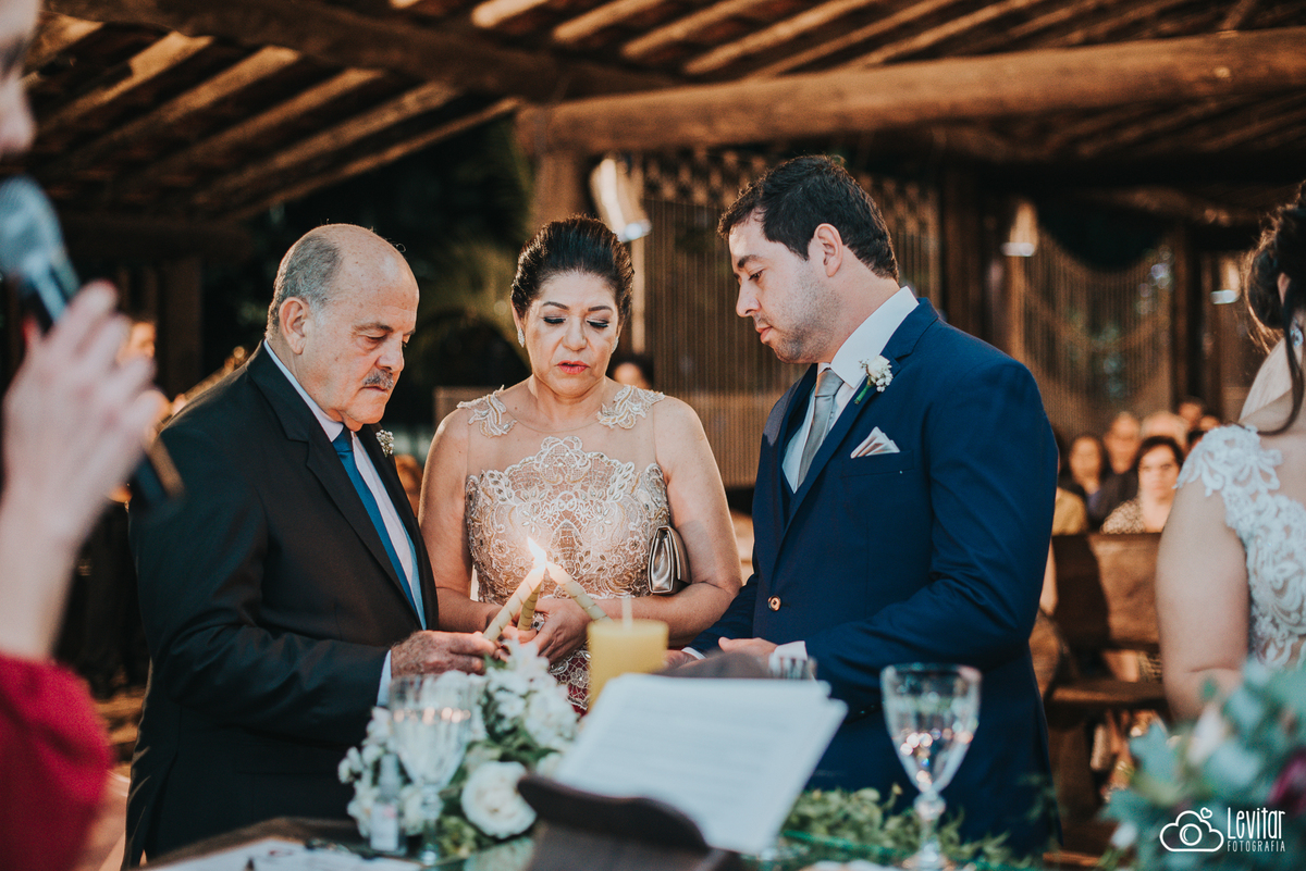 pais acendendo a vela na cerimônia das velas