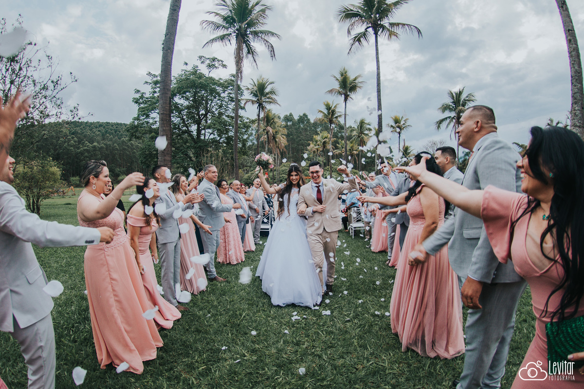 Saída dos noivos com pétalas sendo jogadas pelos padrinhos e madrinhas