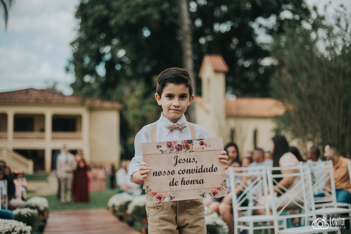 Pajen com plaquinha entrando no casamento
