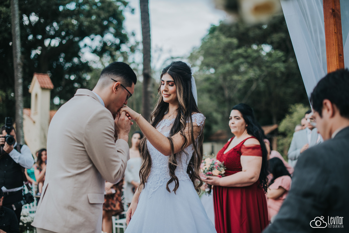 Noivo beijando aliança da Noiva