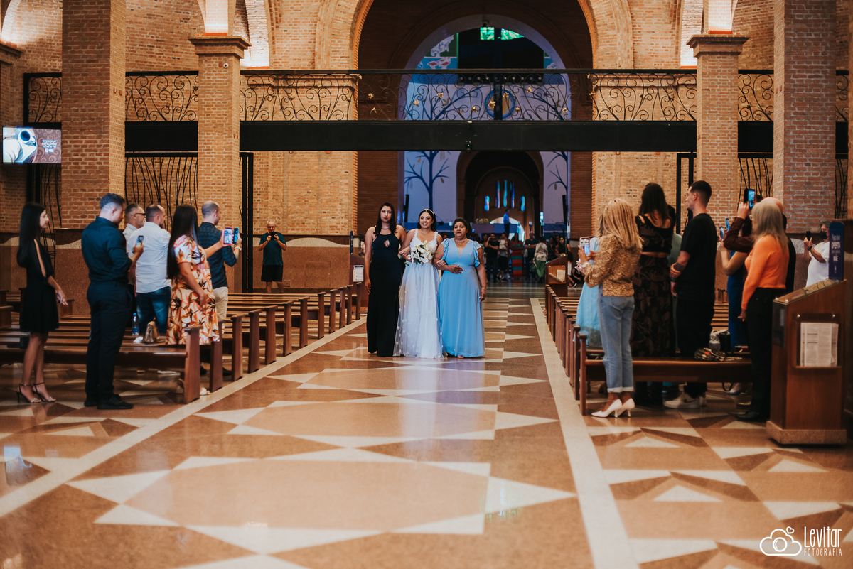 Noiva entrando com mãe e irmã para seu casamento na capela são josé da basilica nacional de aparecida