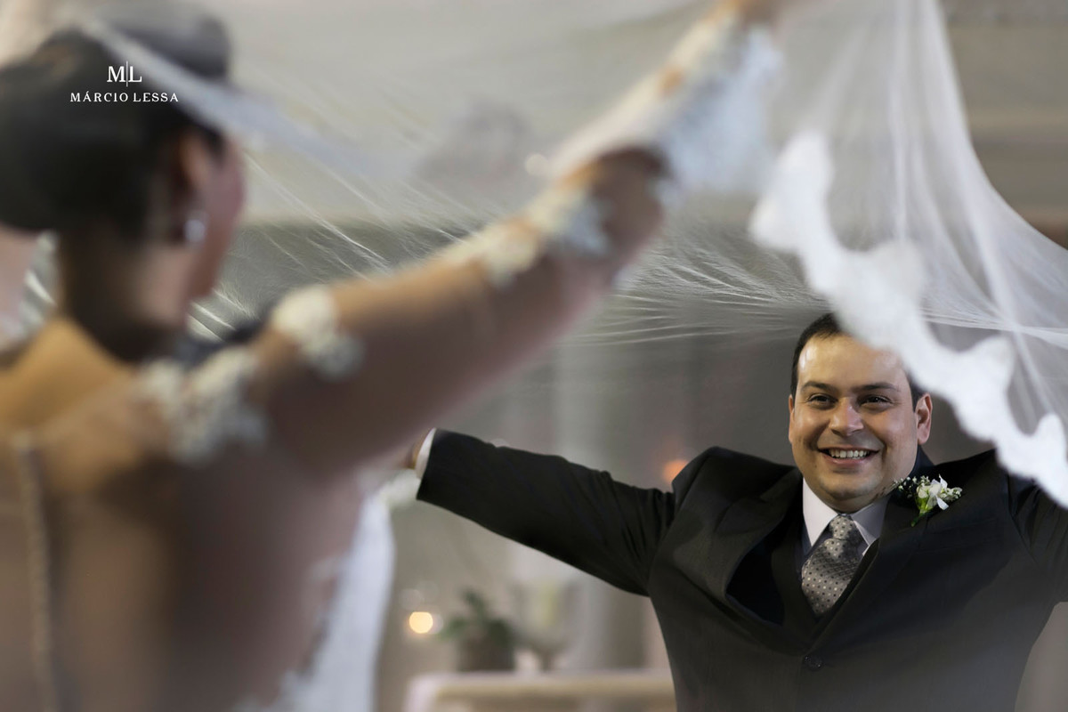 O noivo brincando com o véu da noiva