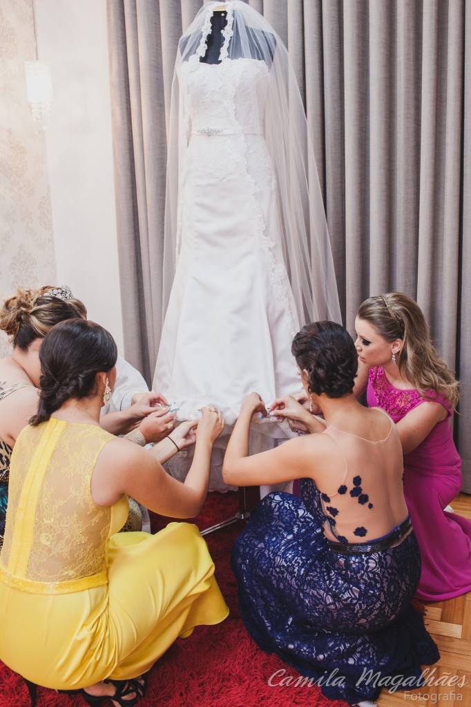 amigas colocando nome na barra do vestido de noiva