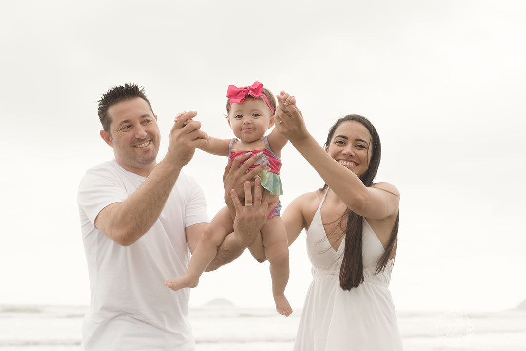 Marina se divertindo com o papai e a mamãe no ensaio realizado na praia