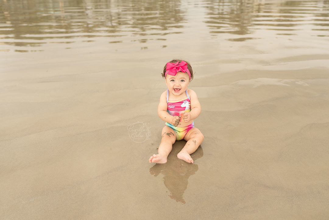 Marina se divertindo com o papai e a mamãe no ensaio realizado na praia, primeiro aninho