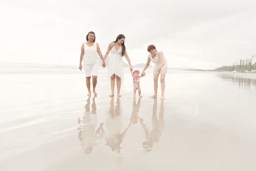 As mulheres da família da Marina juntas no ensaio na praia para comemorar o primeiro aninho