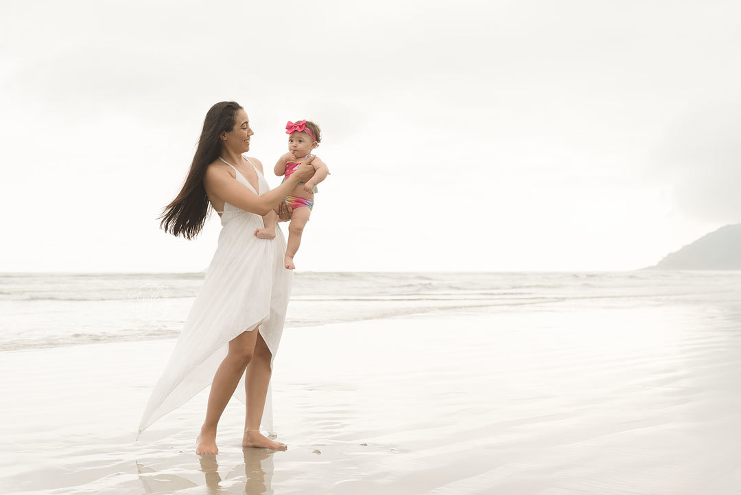 Mamãe e bebê durante o ensaio de fotos na praia