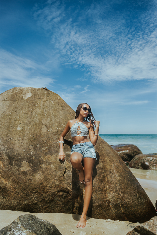 ensaio de debutante rj, debutante encostada na pedra e mexendo nos cabelo, andré nogueira fotografia, praia do secreto rj