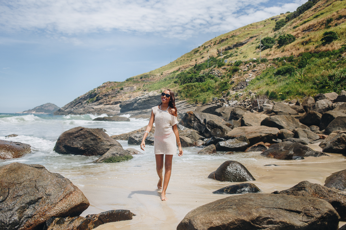 ensaio de debutante rj, debutante caminhando e sorrindo pelas areias da praia do secreto rj, foto por andré nogueira fotografia