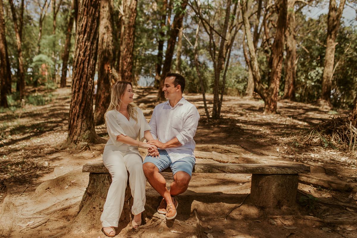 casal sentado de mãos datas no jardim ecológico uaná etê ensaio pré casamento noivos vale dos sonhos fotografo de casamento rj André nogueira fotografia