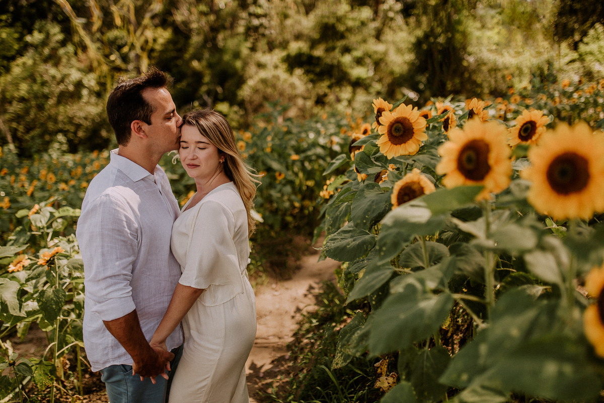 casal do salão vale dos sonhos campo grande sendo fotografado no campo de girassóis do jardim ecológico do uaná etê ensaio pré casamento rj andré nogueira fotografia