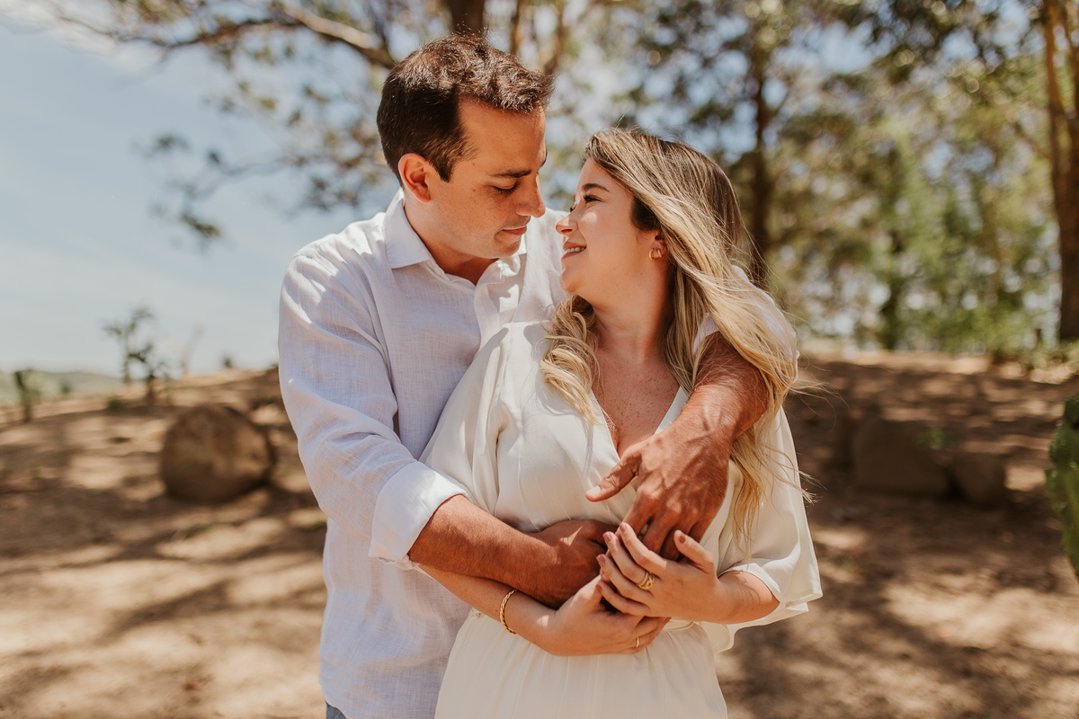 fotografo de casamentos rj casal abraçados e olhando um para o outro durante o ensaio pré casamento realizado no jardim ecológico do uaná etê