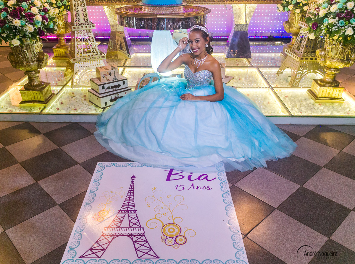fotografia de festa de 15 anos debutante sentada em frente a mesa do bolo por andré nogueira fotografia