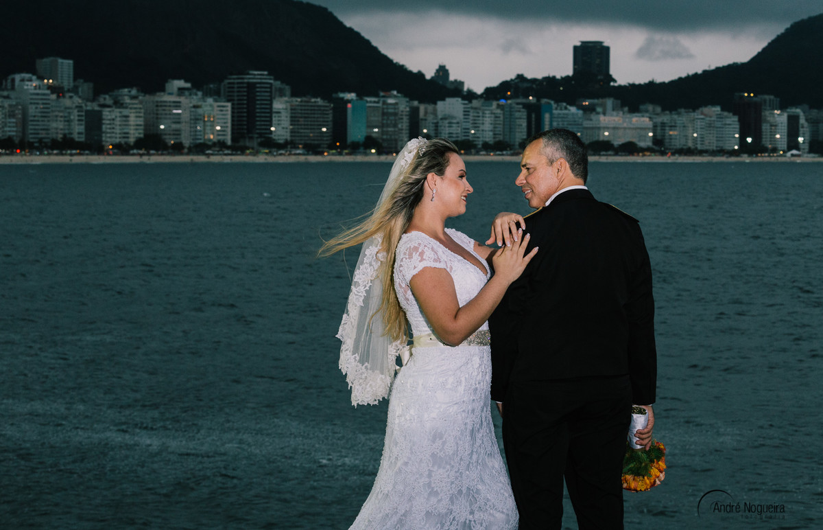 a noiva apoia suas mãos no ombro do noivo enquanto ele olha pra ela clicado por andre nogueira fotografia trash the dress copacabana