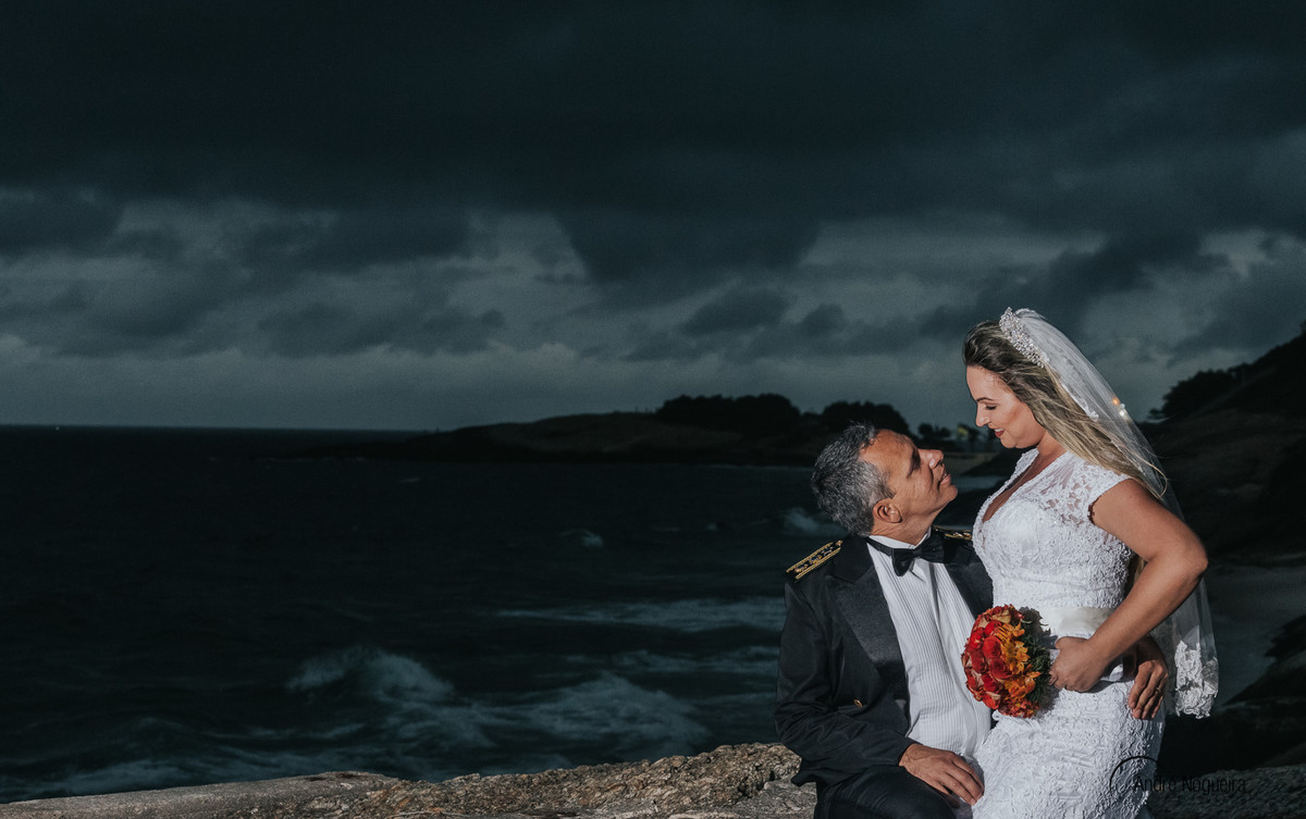 noivas sentada no colo do noivo enquanto saão fotografados pelo fotografo de casamento rj andré nogueira fotografia trash the dress rj