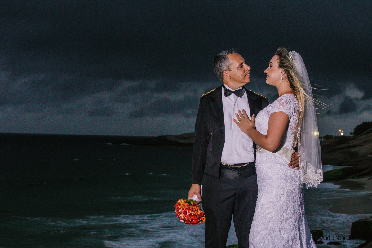 com as mãos no peito do noivo a noiva olha apaixonadamente para ele e eles são fotografados por andré nogueira fotografia fotografo de casamento rj