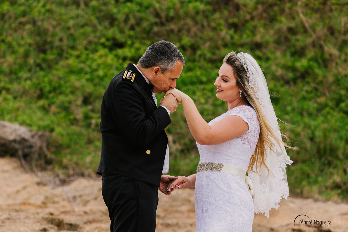 a noiva tem a sua mão beijada pelo noivo e clicada pelo fotografo de casamento rj andré nogueira fotografia