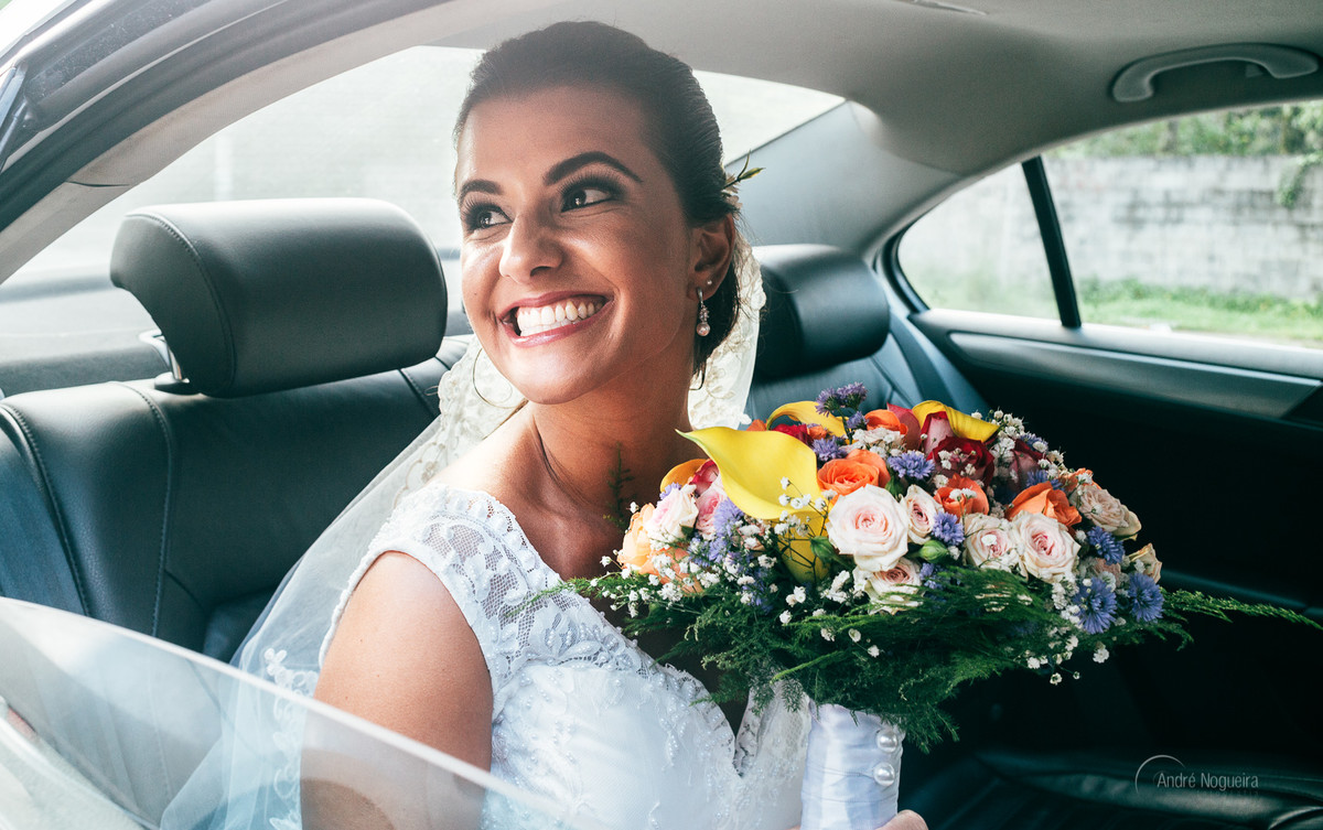 segurando seu bouquet de noiva lindo a noiva espera sorridente no carro a hora da sua entrada na cerimonia de dia no espaço coliseu vargem grande