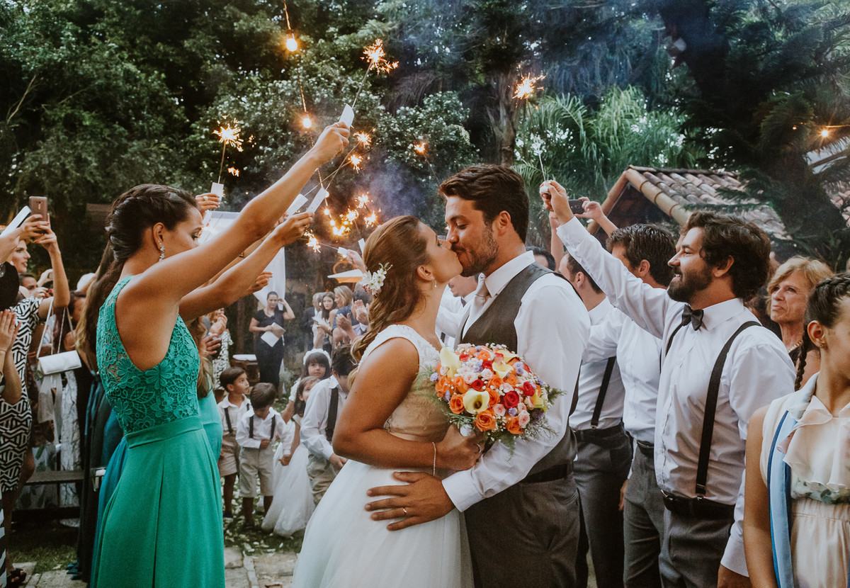 noivos se beijam no final do corredor formado pelos padrinho, andre nogueira fotografia, coliseu vargem grande