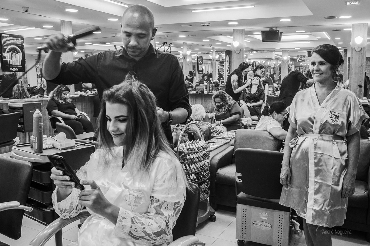 noiva mexendo no celular durante o seu making of noiva rj e sua mãe olha sorridente o momento, registradio por andré nogueira fotografia, espaço coliseu vargem grande, fotografo de casamento rj