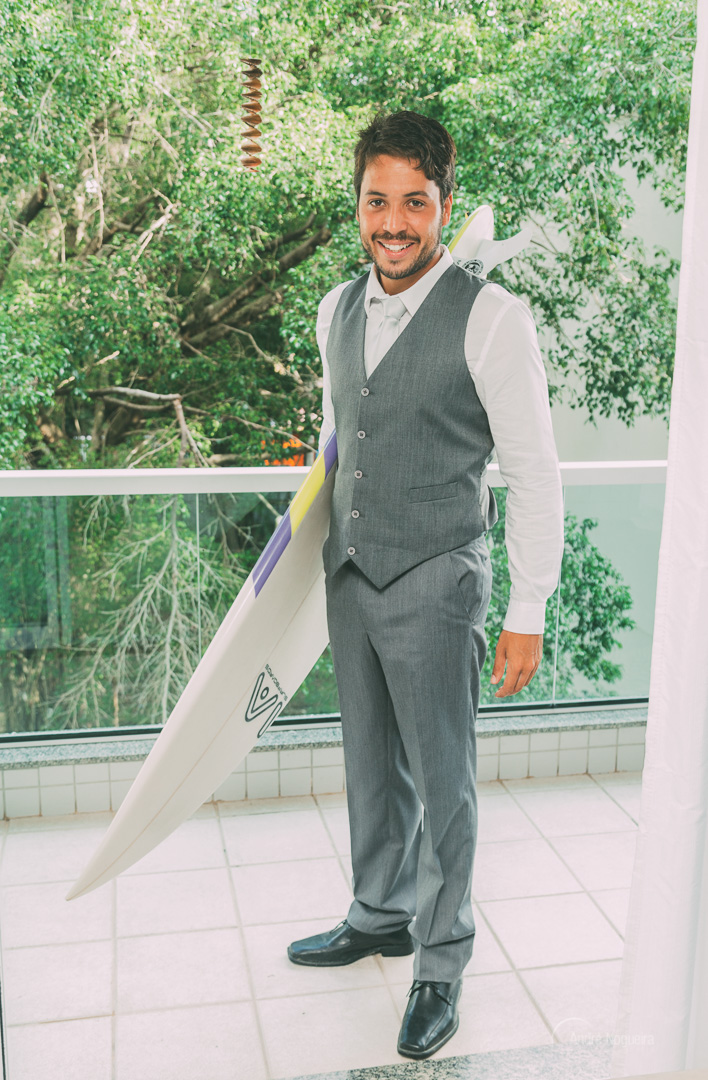 segurando a sua prancha na varanda de sua casa o noivo é fotografado por andré nogueira fotografia
