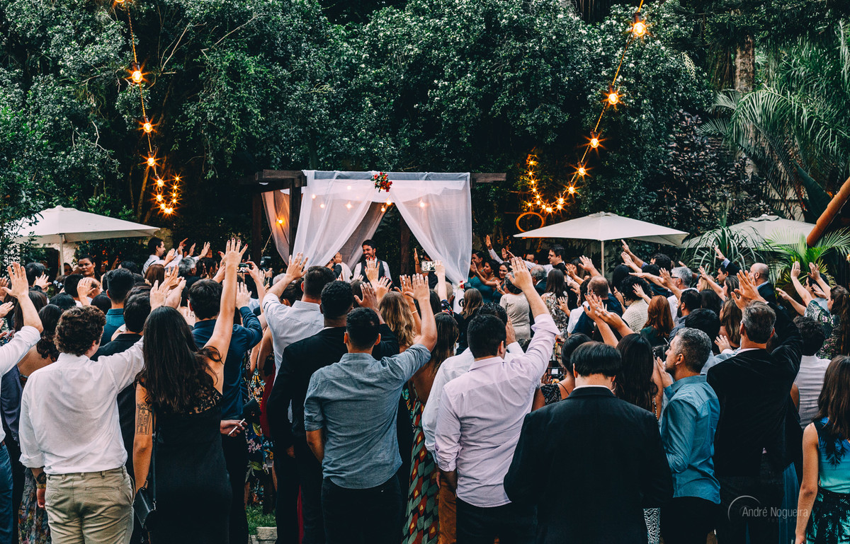 no jardim do espaço coliseu vargem grande os convidados esticam as mãos para abençoar os noivos, casamento de dia, andre nogueira fotografia