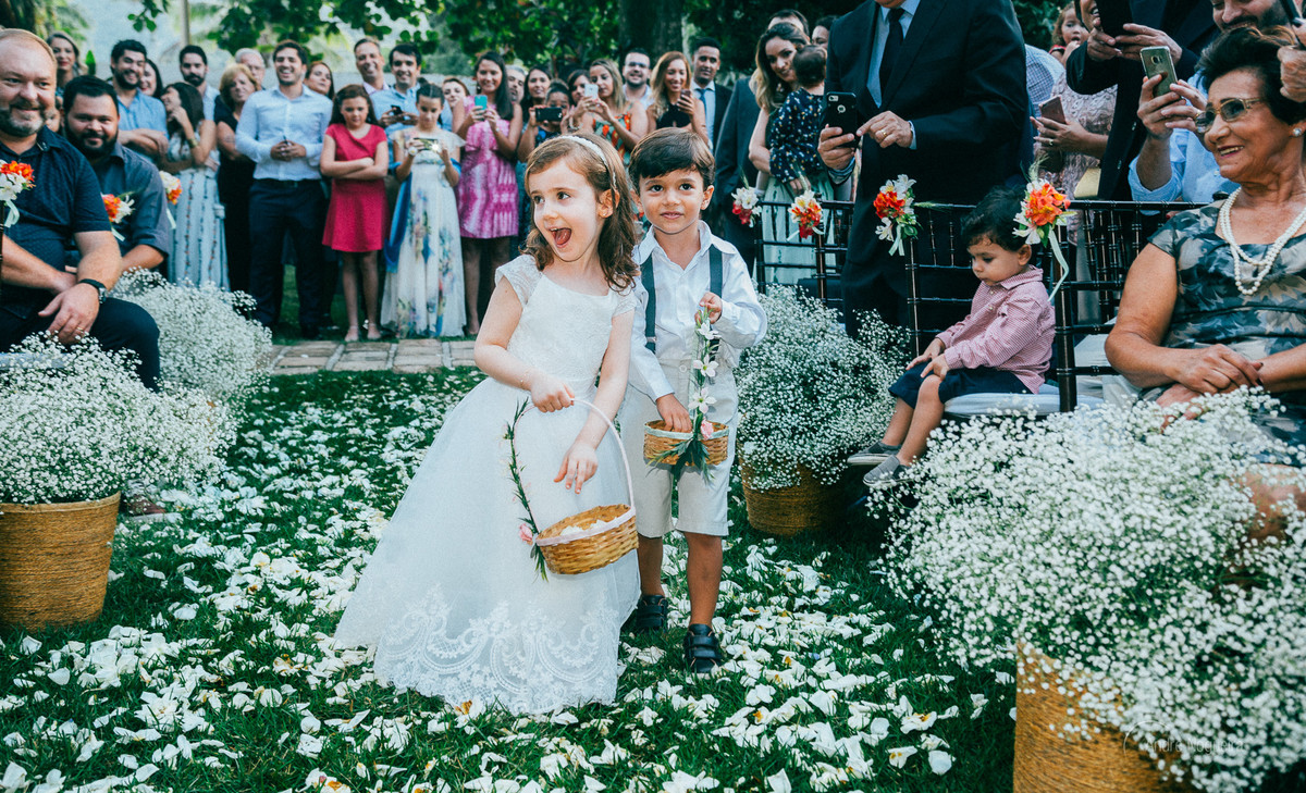 fotografia de casamento de dia rj daminha e pajem vem jogando pétalas de rosa antes da noiva entrar