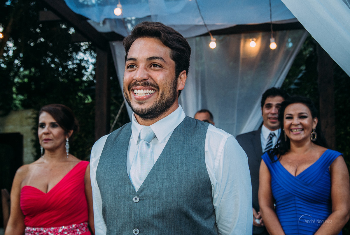com um sorriso lindo no rosto o noivo espera junto com seus pais no altar a entrada da noiva espaço coliseu vargem grande casamento de dia