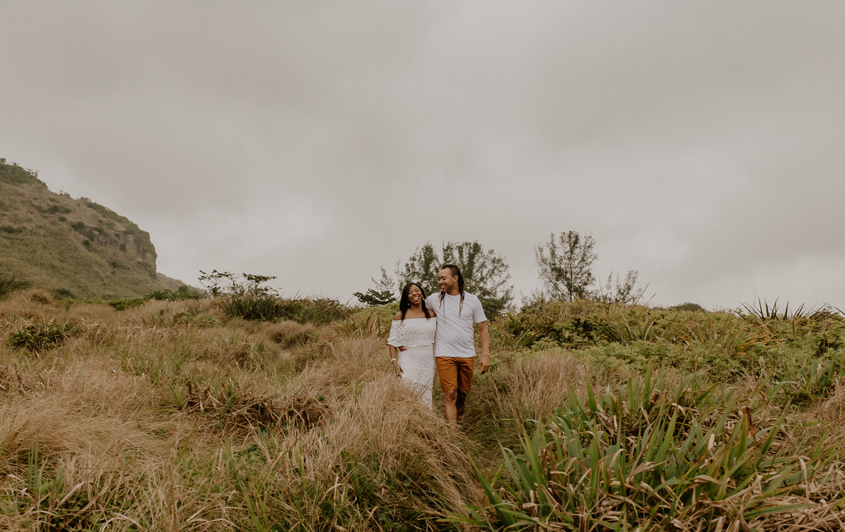 casal andando abraçado durante a sessão de fotos pre casamento na praia de grumari e prainha
