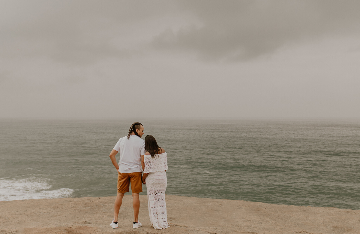casal rj abraçados admirando o mar durante o ensaio de casal pre casamento rj na prainha no recreio dos bandeirantes