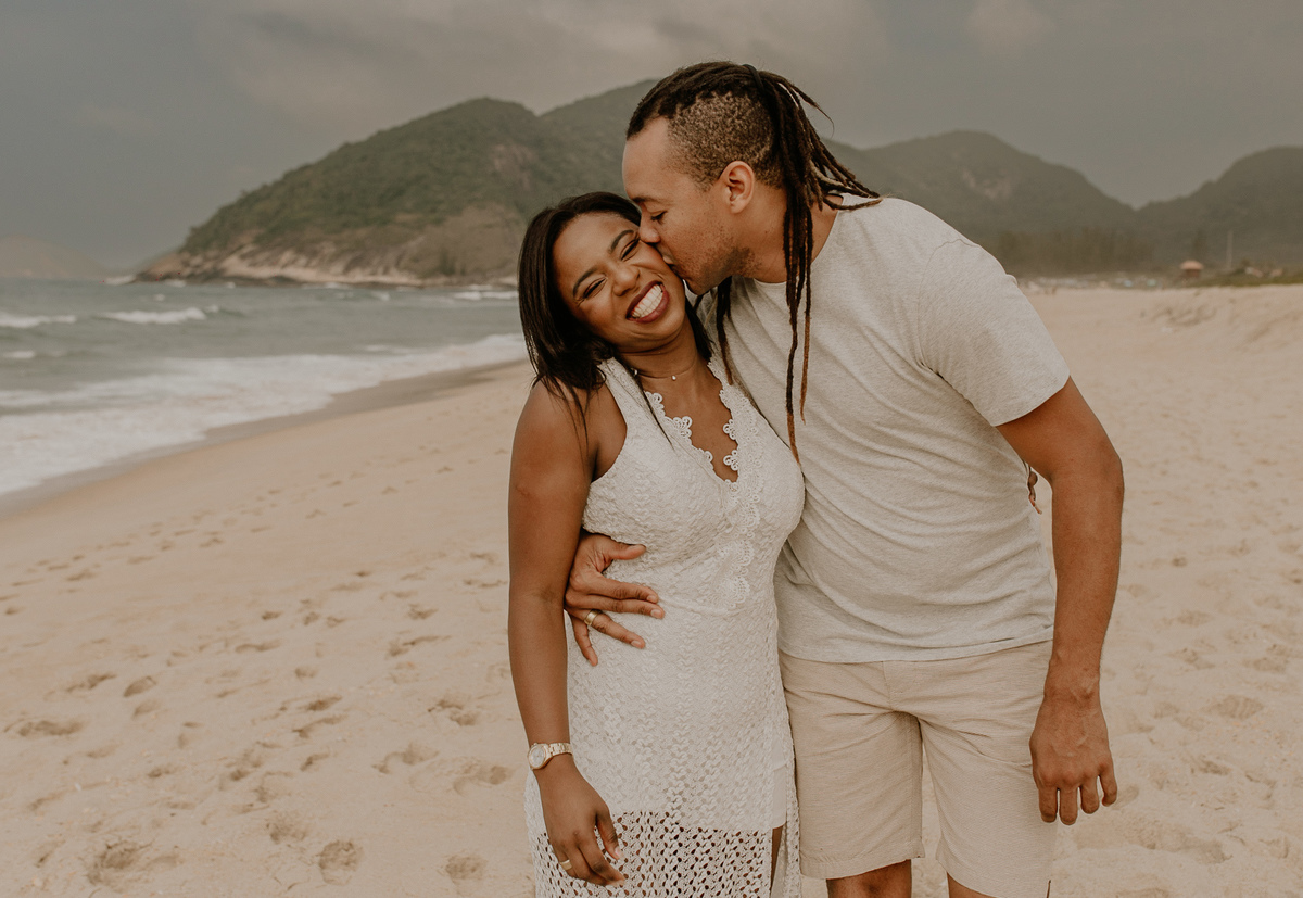 noivo beijando a noiva durante ensaio casal romantico na praia de grumari rio de janeiro por andré nogueira fotografia especialista ensaios fotograficos de casais no rio de janeiro