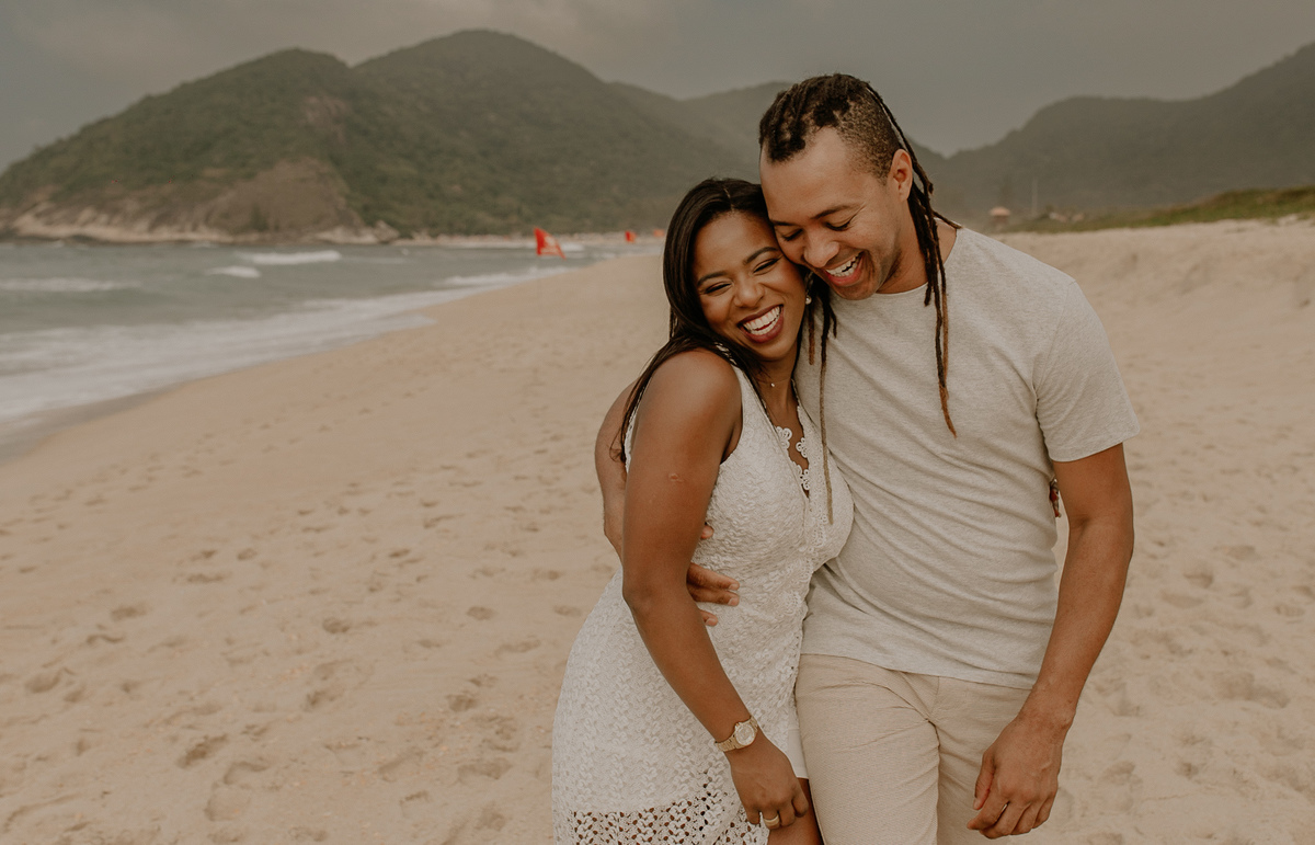 ensaio fotografico casal romantico na praia de grumari rj casal andando abraçado pelas areias da praia