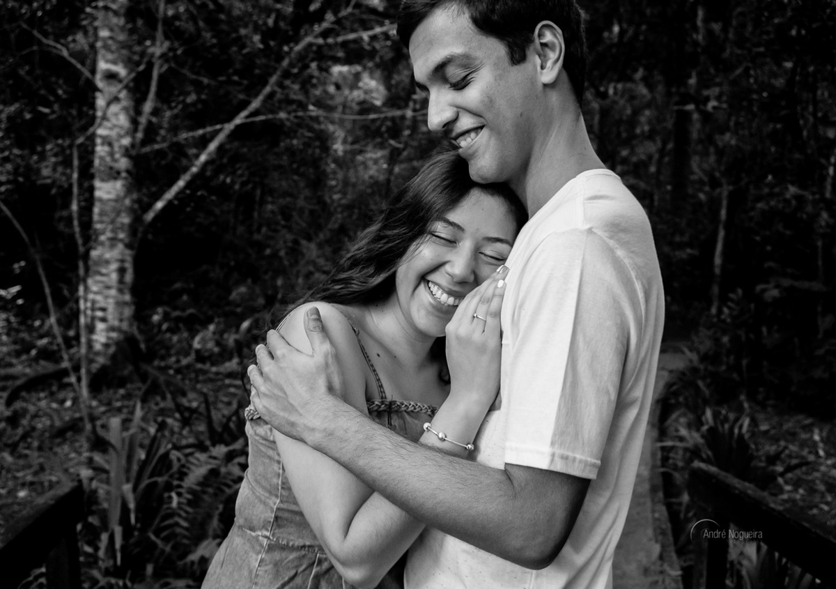 sorridente a noiva encostada a cabeça no peito do noivo enquanto ele abraça ela durante o ensaio pre casamento