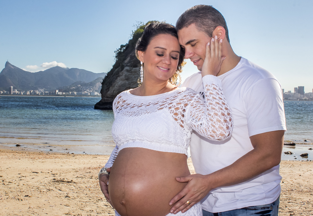gestante alisando o rosto do marido na praia de boa viagem