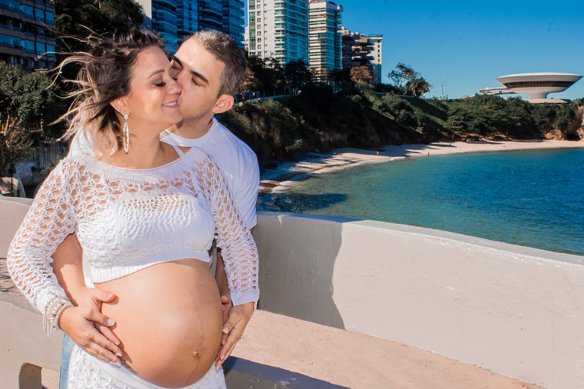 casal se beijando praia de boa viagem com museu Mac de niteroi ao fundo
