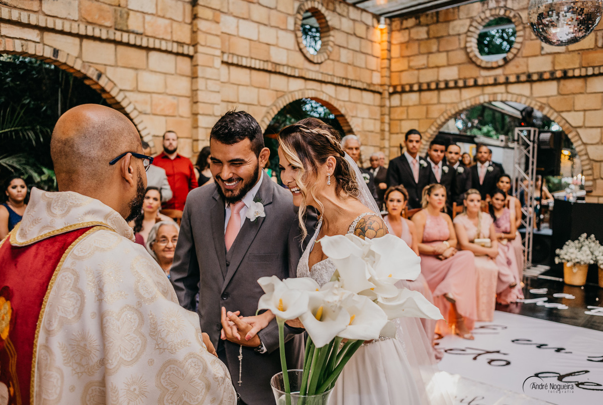 durante a cerimonia celebrada peelo padre wagner neto os noivos sorriem na cerimonia espaço coliseu vargem grande
