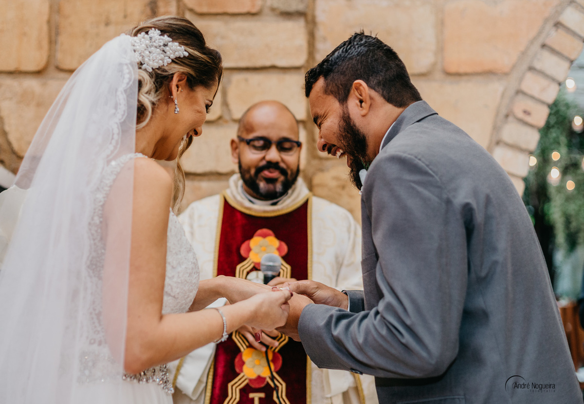 noivo sorri enquanto coloca a aliança na noiva espaço coliseu eventos vargem grande