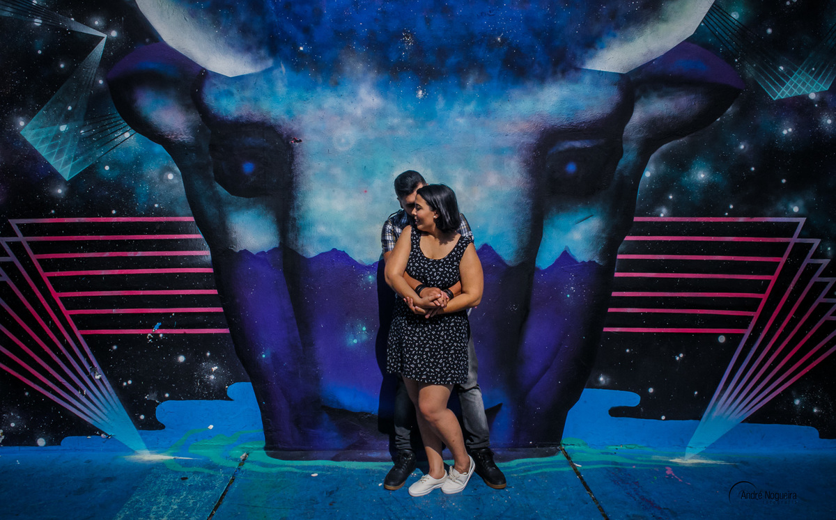 em frente ao muro grafitado casal abraçado beco do batman noivas sp