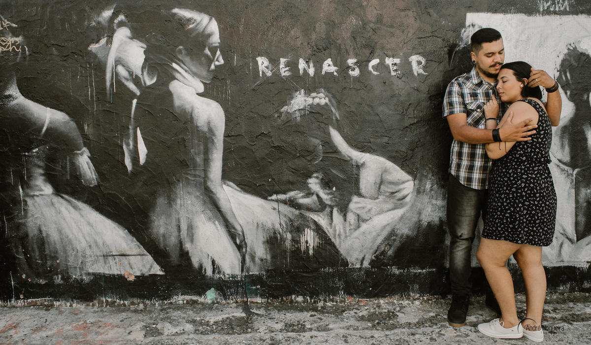 noivos abraçados em frente a parede grafitada renascer no beco do batman