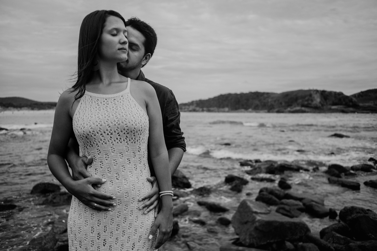 durante o ensaio casal rj em cabo frio na praia das conchas o noivo beija o rosto da noiva