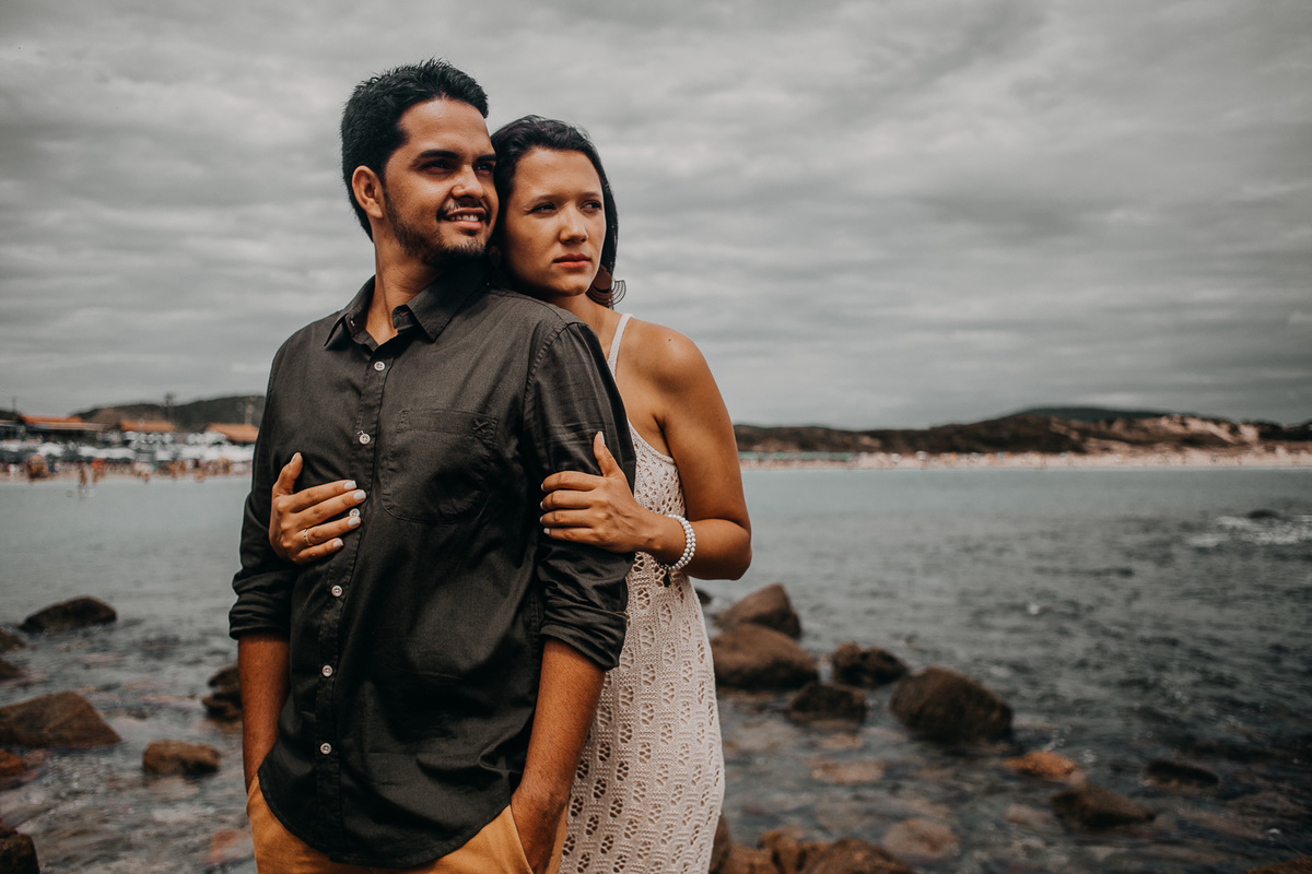 abraçados na praia das conchas em cabo frio casal admira a paisagem durante o ensaio casal rj