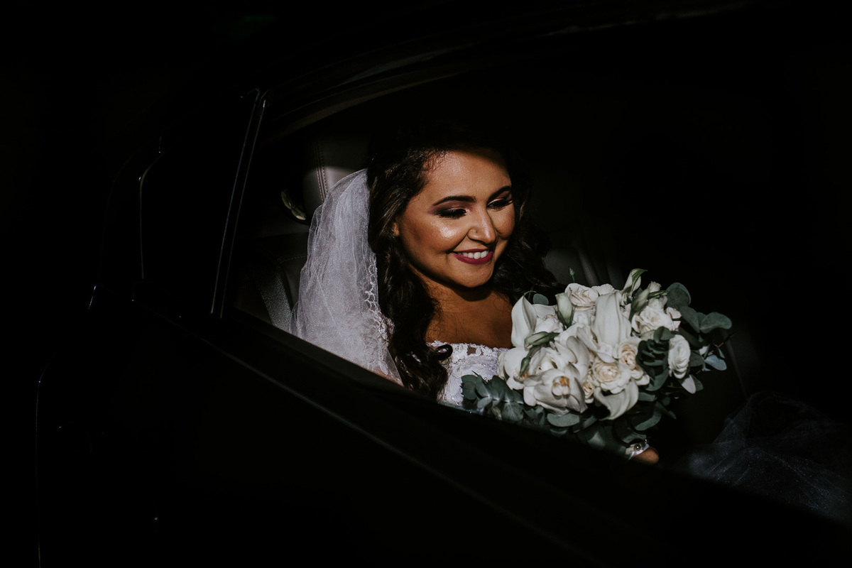 no lindo jardim do sitio das palmeiras a noiva olha seu lindo bouquet de noiva dentro do carro