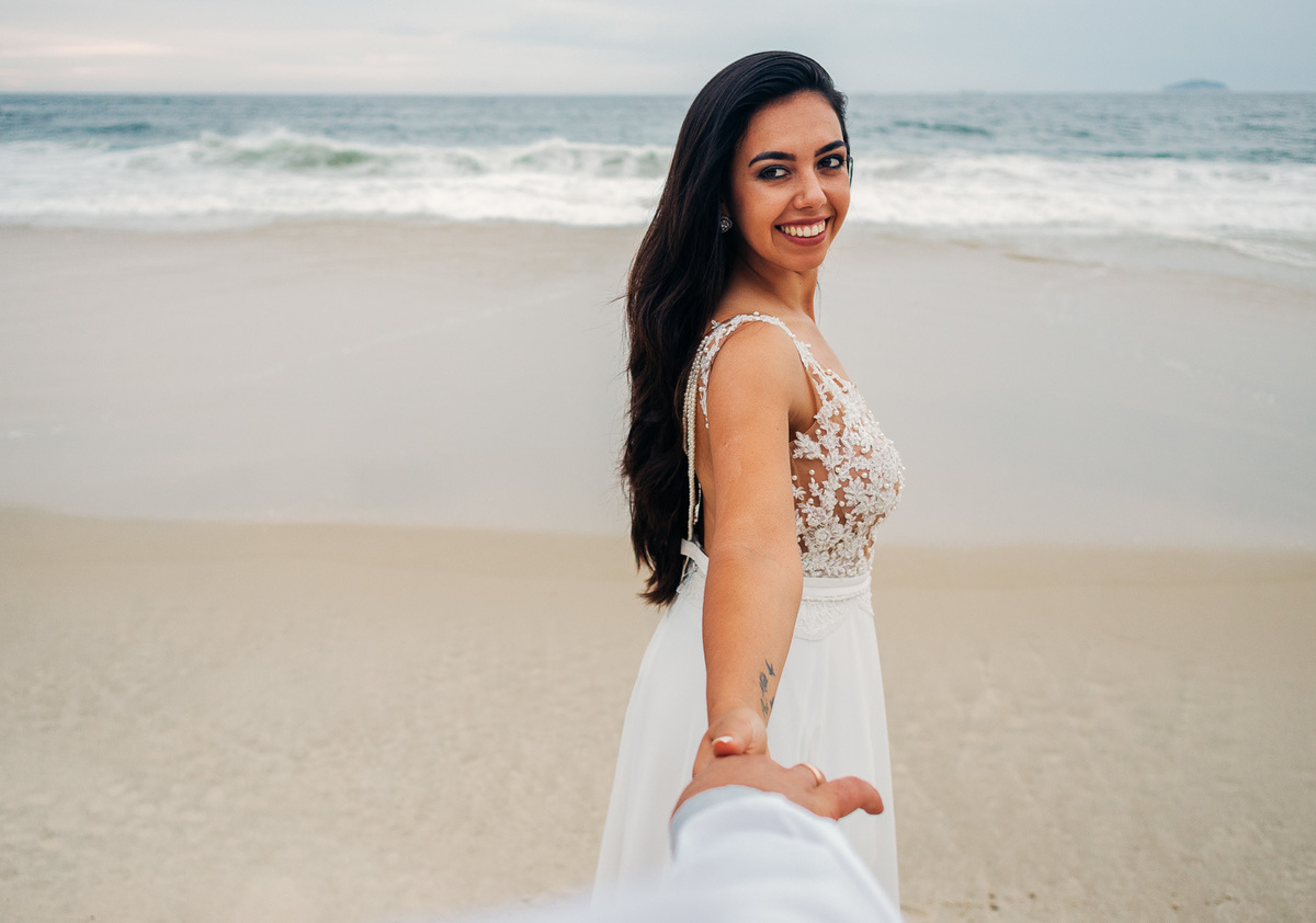 noiva segurando a mão do noivo no ensaio pre casamento forte de copacabana