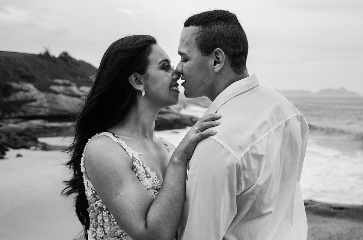 se beijando casal está em pé na pedra do forte de copacabana pre casamento