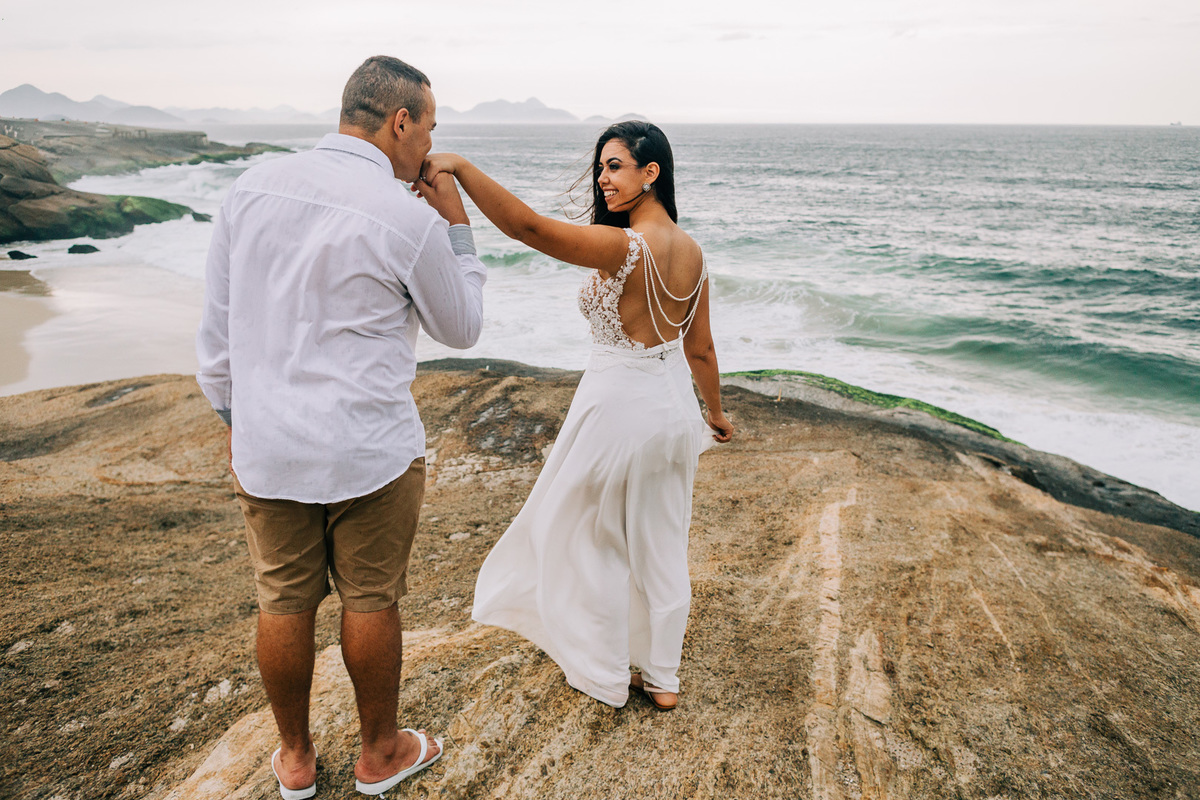 noivo beija a mão da noiva pre casamento forte de copacabana vestidod e noiva