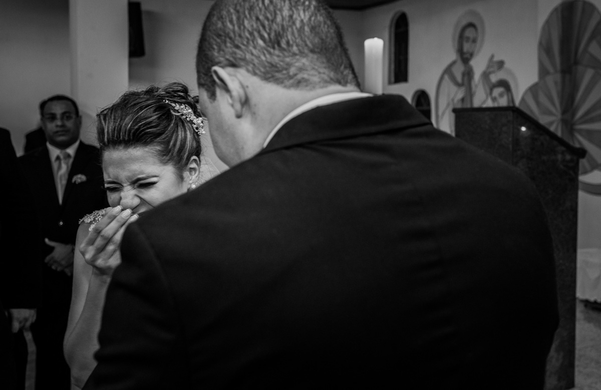noiva sorri enquanto o noivo lê os votos de casamento na igreja católica mansão das estrelas