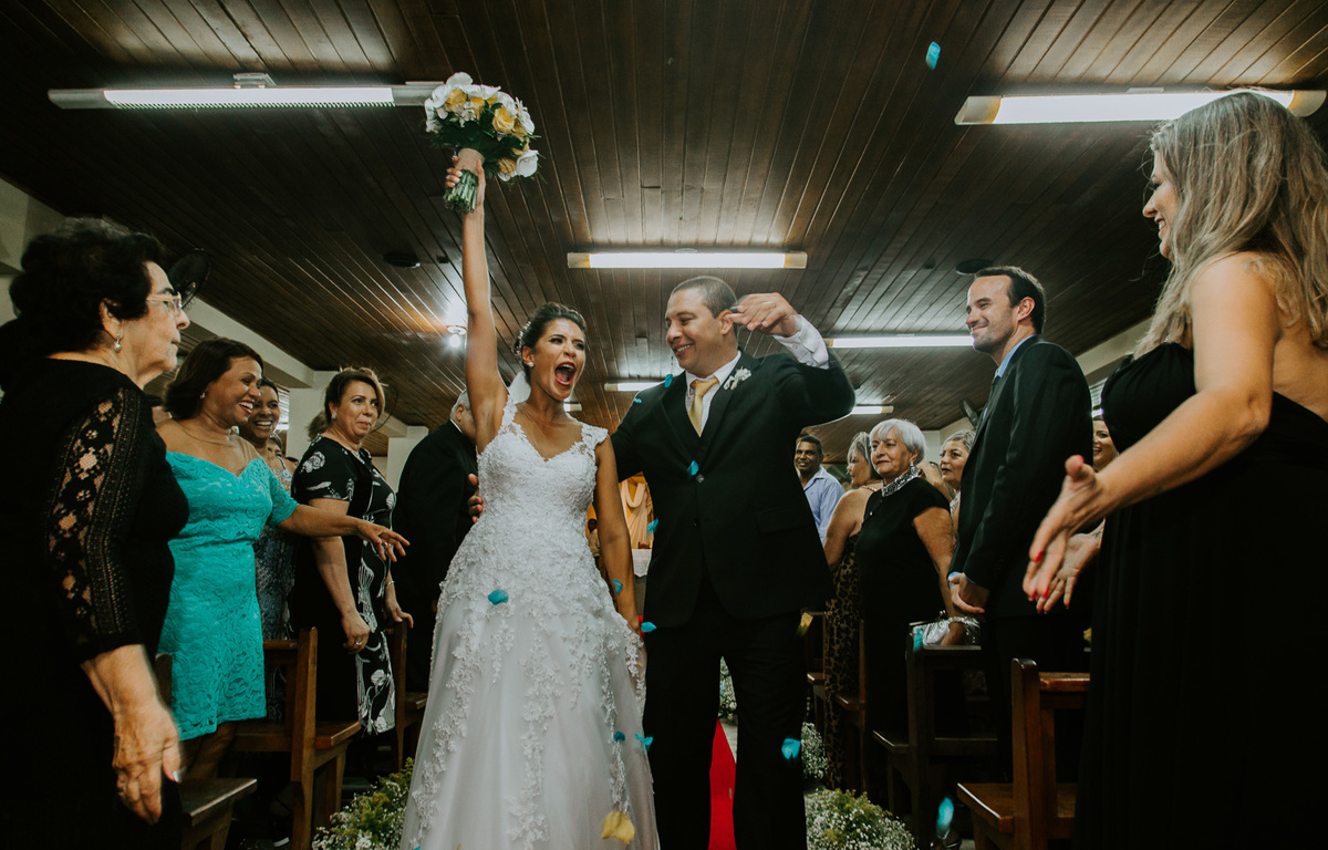 noivos comemorando na saida da cerimonia de casamento