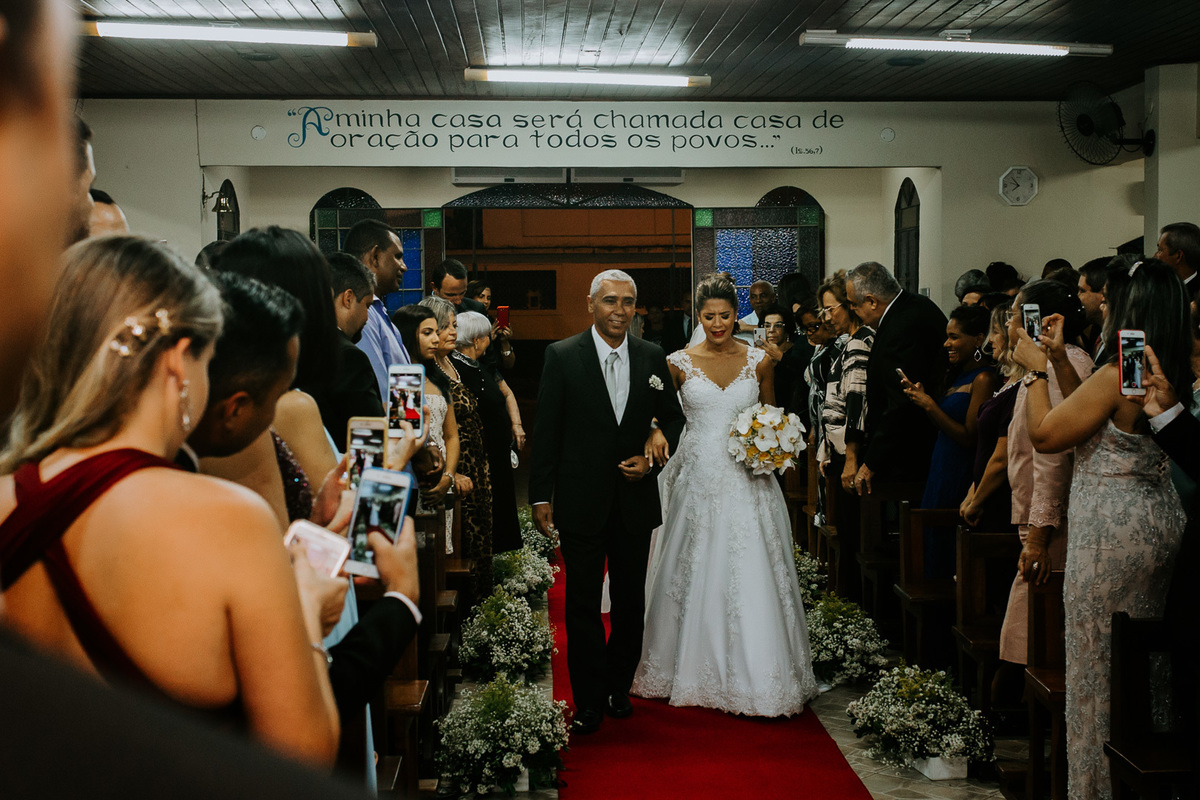 noiva entrando na igreja católica para a cerimonia de casamento com o vestido da morena andrade atelier salão de festa Mansão das Estrelas